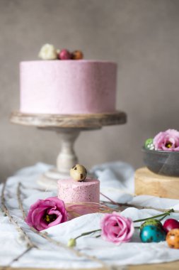 Paskalya masa dekorasyonu, bahar çiçekleri ve tatil masada boyalı yumurta ile lezzetli ev yapımı kekler 