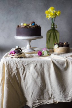 Vazoda Çiçekler ile Paskalya için çikolatalı kek. Tatil masa dekorasyonu Paskalya kek, çiçek ve renkli yumurta