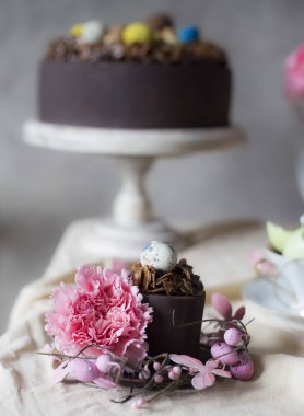 Vazoda Çiçekler ile Paskalya için çikolatalı kek. Tatil masa dekorasyonu Paskalya kek, çiçek ve renkli yumurta