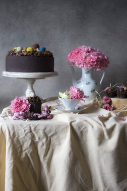 Vazoda Çiçekler ile Paskalya için çikolatalı kek. Tatil masa dekorasyonu Paskalya kek, çiçek ve renkli yumurta