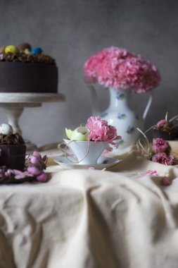 Vazoda Çiçekler ile Paskalya için çikolatalı kek. Tatil masa dekorasyonu Paskalya kek, çiçek ve renkli yumurta