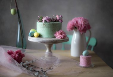 Paskalya masa dekorasyonu, lezzetli ev yapımı kek bahar çiçekleri ve tatil masada boyalı yumurta 