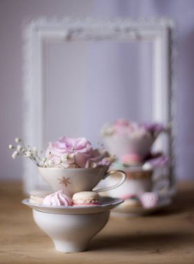 Closeup bardak ve çiçeklerle süslü masada kurabiye