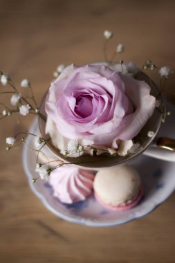 Closeup Kupası ve çiçeklerle süslü masada kurabiye   