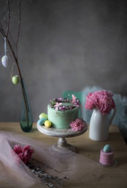 Paskalya masa dekorasyonu, lezzetli ev yapımı kek bahar çiçekleri ve tatil masada boyalı yumurta 