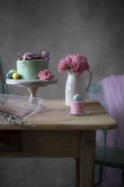 Paskalya masa dekorasyonu, lezzetli ev yapımı kek bahar çiçekleri ve tatil masada boyalı yumurta 