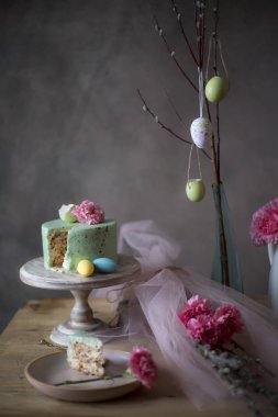 Acı dolu yumurta ve bahar çiçekleri ile dekore edilmiş tatil tabloda ev yapımı Paskalya pasta dilimi closeup