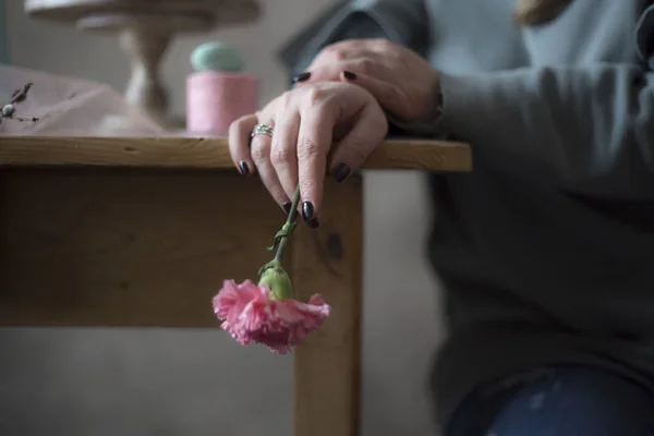 Primer Plano Las Manos Femeninas Sosteniendo Flor Rosa Cerca Mesa — Foto de Stock