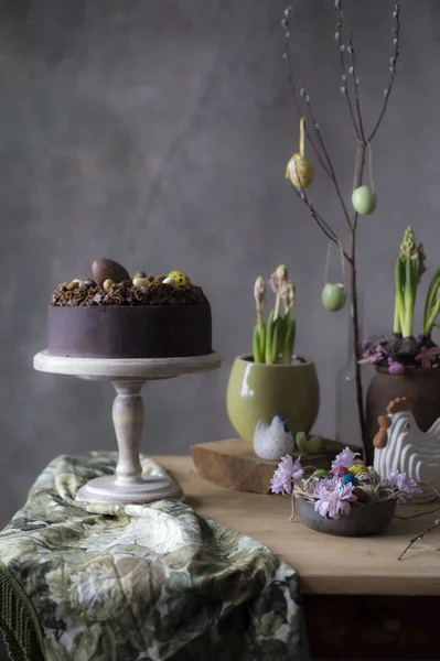 Ostertischdekoration Schokoladenkuchen Mit Frühlingsblumen Und Bemalten Eiern Auf Dem Festtagstisch — Stockfoto
