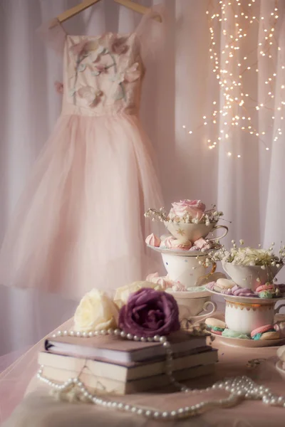 ケーキ 道具の装飾が施されたテーブルの後ろの壁に掛かっている小さな女性はドレスアップ — ストック写真