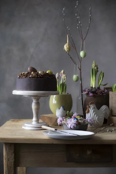 Ostertischdekoration Schokoladenkuchen Mit Frühlingsblumen Und Bemalten Eiern Auf Dem Festtagstisch — Stockfoto
