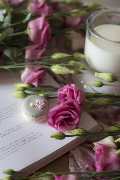 Closeup of colorful spring flowers bouquet with cookies and book on table