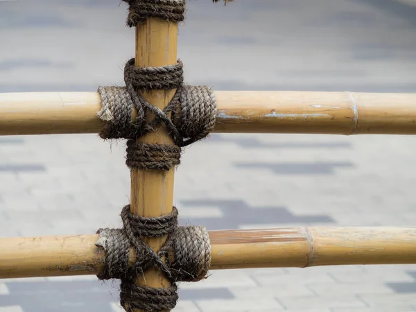 Бамбуковый забор с привязанной веревкой — стоковое фото