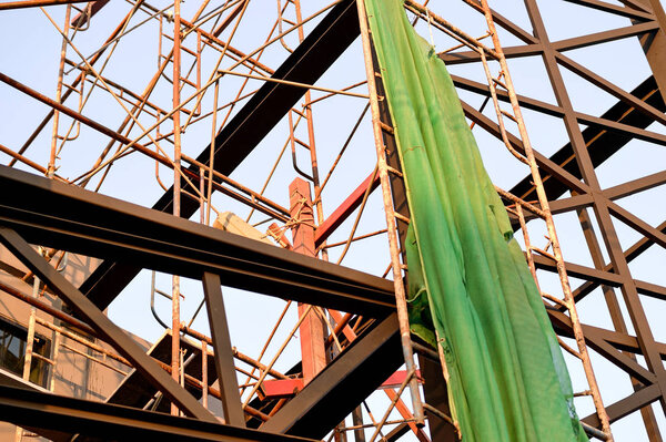 Building under construction wrapped in a green net for safety