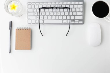 Bilgisayar laptop, fincan kahve, defter ve diğer malzemeleri ile modern beyaz ofis Resepsiyon üst tablo. Beyaz arka plan üzerinde üstten görünüm kopya alanı ile. Üstten Görünüm, düz yatıyordu.