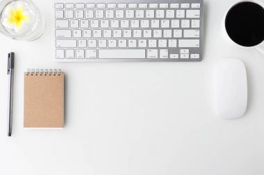 Bilgisayar laptop, fincan kahve, defter ve diğer malzemeleri ile modern beyaz ofis Resepsiyon üst tablo. Beyaz arka plan üzerinde üstten görünüm kopya alanı ile. Üstten Görünüm, düz yatıyordu.