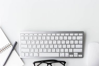 Modern beyaz ofis masa üstü bilgisayar laptop, defter ve diğer malzemeleri ile tablo. Beyaz arka plan üzerinde üstten görünüm kopya alanı ile. Üstten Görünüm, düz yatıyordu.