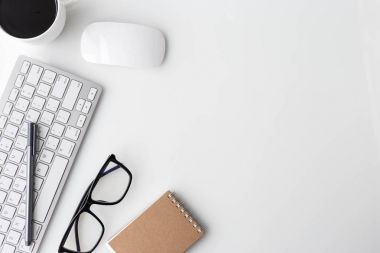 Bilgisayar laptop, fincan kahve, defter ve diğer malzemeleri ile modern beyaz ofis Resepsiyon üst tablo. Beyaz arka plan üzerinde üstten görünüm kopya alanı ile. Üstten Görünüm, düz yatıyordu.