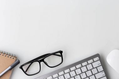 Modern beyaz ofis masa üstü bilgisayar laptop, defter ve diğer malzemeleri ile tablo. Beyaz arka plan üzerinde üstten görünüm kopya alanı ile. Üstten Görünüm, düz yatıyordu.