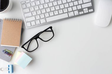 Bilgisayar laptop, fincan kahve, defter ve diğer malzemeleri ile modern beyaz ofis Resepsiyon üst tablo. Beyaz arka plan üzerinde üstten görünüm kopya alanı ile. Üstten Görünüm, düz yatıyordu.