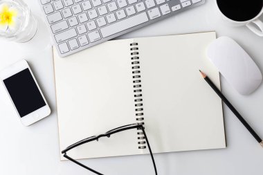 Bilgisayar laptop, fincan kahve, defter ve diğer malzemeleri ile modern beyaz ofis Resepsiyon üst tablo. Beyaz arka plan üzerinde üstten görünüm kopya alanı ile. Üstten Görünüm, düz yatıyordu.