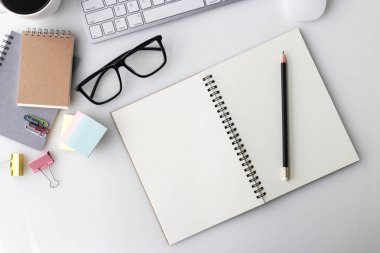 Bilgisayar laptop, fincan kahve, defter ve diğer malzemeleri ile modern beyaz ofis Resepsiyon üst tablo. Beyaz arka plan üzerinde üstten görünüm kopya alanı ile. Üstten Görünüm, düz yatıyordu.