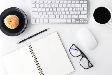 Bilgisayar laptop, bir fincan kahve, defter ve diğer malzemeleri ile modern beyaz ofis Resepsiyon üst tablo. Beyaz arka plan üzerinde üstten görünüm kopya alanı ile. Üstten Görünüm, düz yatıyordu.