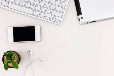 Modern beyaz ofis masa üstü bilgisayar dizüstü, akıllı telefon, tablet ve diğer malzemeleri ile tablo. Beyaz arka plan üzerinde üstten görünüm kopya alanı ile. Üstten Görünüm, düz yatıyordu.