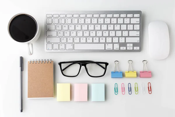 Moderna mesa de escritorio de oficina blanca con computadora portátil, taza de café, portátil y otros suministros. Vista superior con espacio de copia sobre fondo blanco. Vista superior, plano . —  Fotos de Stock