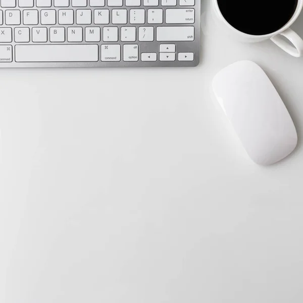 Moderna mesa de escritorio de oficina blanca con computadora portátil, taza de café, portátil y otros suministros. Vista superior con espacio de copia sobre fondo blanco. Vista superior, plano . — Foto de Stock