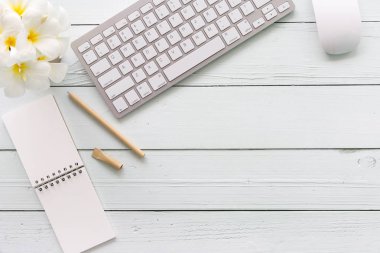 Modern beyaz ofis Resepsiyon üst ahşap masa bilgisayar dizüstü bilgisayar ve diğer malzemeleri. Beyaz arka plan üzerinde üstten görünüm kopya alanı ile. Üstten Görünüm, düz yatıyordu.