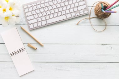 Modern beyaz ofis Resepsiyon üst ahşap masa bilgisayar dizüstü bilgisayar ve diğer malzemeleri. Beyaz arka plan üzerinde üstten görünüm kopya alanı ile. Üstten Görünüm, düz yatıyordu.