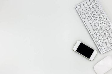 Modern ofis masa üstü bilgisayar dizüstü, akıllı telefon ve diğer malzemeleri ile tablo. Beyaz arka plan üzerinde üstten görünüm kopya alanı ile. Üstten Görünüm, düz yatıyordu.