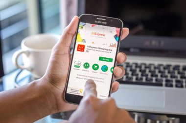 Chiang Mai, Tayland - 1 Şubat 2017: Asya adam aliexpress alibaba app üstünde belgili tanımlık perde Resepsiyon Office ile Samsung Galaxy S6 tutarak. İş çalışma alanı'nın Üstten Görünüm.