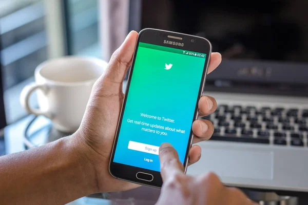 Chiang Mai, Tayland - 1 Şubat 2017: Asya adam heyecan app üstünde belgili tanımlık perde Resepsiyon Office ile Samsung Galaxy S6 tutarak. İş çalışma alanı'nın Üstten Görünüm.