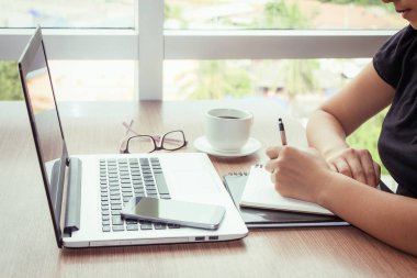 Yakın kadar kadın el cep telefonu ve dizüstü bilgisayar reklam metin mesajı veya içerik iş Vintage etkisi için boş kopyalama alanı ekranı ile kullanma.