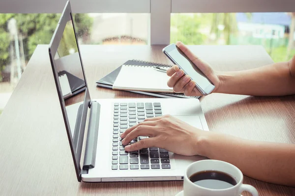 Close Up of woman hands using mobile phone and laptop computer with blank copy space screen for your advertising text message or content business in the Vintage effect. — Stock Photo, Image