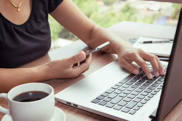 Close Up kobieta rąk przy użyciu telefonu komórkowego i laptopa z pustą kopię miejsca na ekranie dla firmy wiadomości lub treści tekstu reklamy w efekt Vintage. — Zdjęcie stockowe