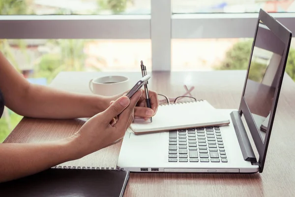 Close Up of woman hands using mobile phone and laptop computer with blank copy space screen for your advertising text message or content business in the Vintage effect. — Stock Photo, Image