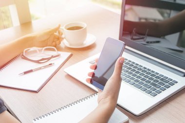 Yakın kadar kadın el cep telefonu ve dizüstü bilgisayar reklam metin mesajı veya içerik iş Vintage etkisi için boş kopyalama alanı ekranı ile kullanma.