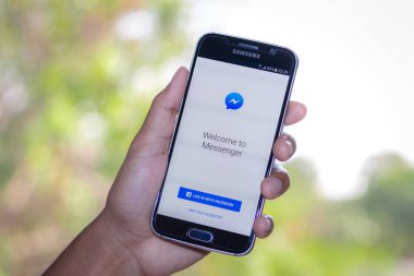 Chiang Mai, Tayland - 3 Şubat 2017: Akıllı telefon Samsung Galaxy S6 apps facebook haberci kullanma üstünde belgili tanımlık perde masaya açmak.