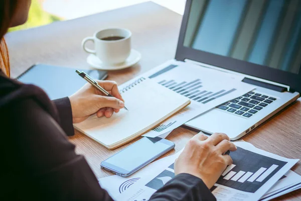 Close Up businessmen working at a coffee shop with a document with a smartphone and a laptop computer. — Stock Photo, Image