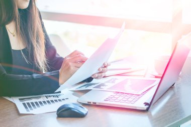 Bir smartphone ve bir dizüstü bilgisayar ile bir belgeyle bir kahve dükkanında çalışan kadar yakın işadamları.