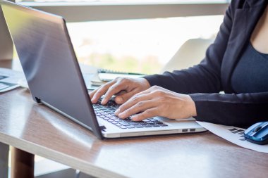 Bir smartphone ve bir dizüstü bilgisayar ile bir belgeyle bir kahve dükkanında çalışan kadar yakın işadamları.