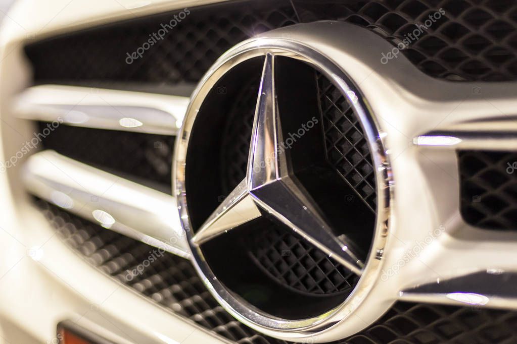ABU DHABI, UAE - NOV 26, 2016: Mercedes Benz company logo on a car illuminated at night
