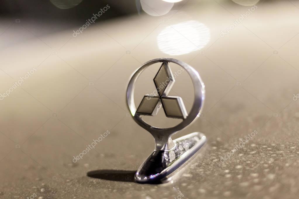 ABU DHABI, UAE - NOV 26, 2016: Mitsubishi Motors company logo on a car illuminated at night