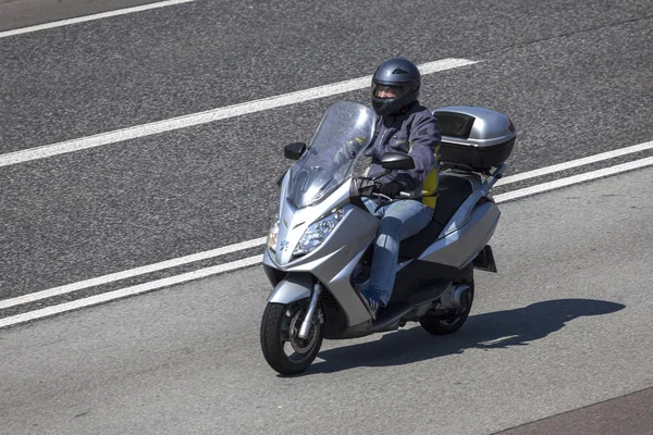 Homem montando uma scooter na estrada — Fotografia de Stock