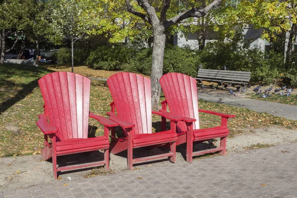 Röda stolar i en stadspark — Stockfoto