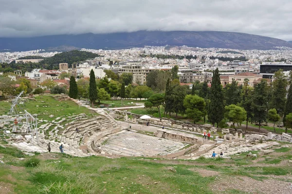 Antiguas ruinas griegas del teatro Dionisio, ruinas en medio de exuberante hierba verde. Acrópolis, Atenas, Grecia . — Foto de Stock