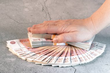 Yığınla kırmızı 5000 rusya rublesi. Üstünde de eli olan banknotlar.